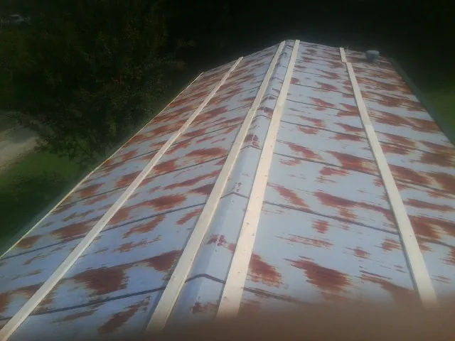 Rusted metal roof panels with new wood purlins before replacement — Storm Damage Roof Repair in Keller by Roofing Brothers